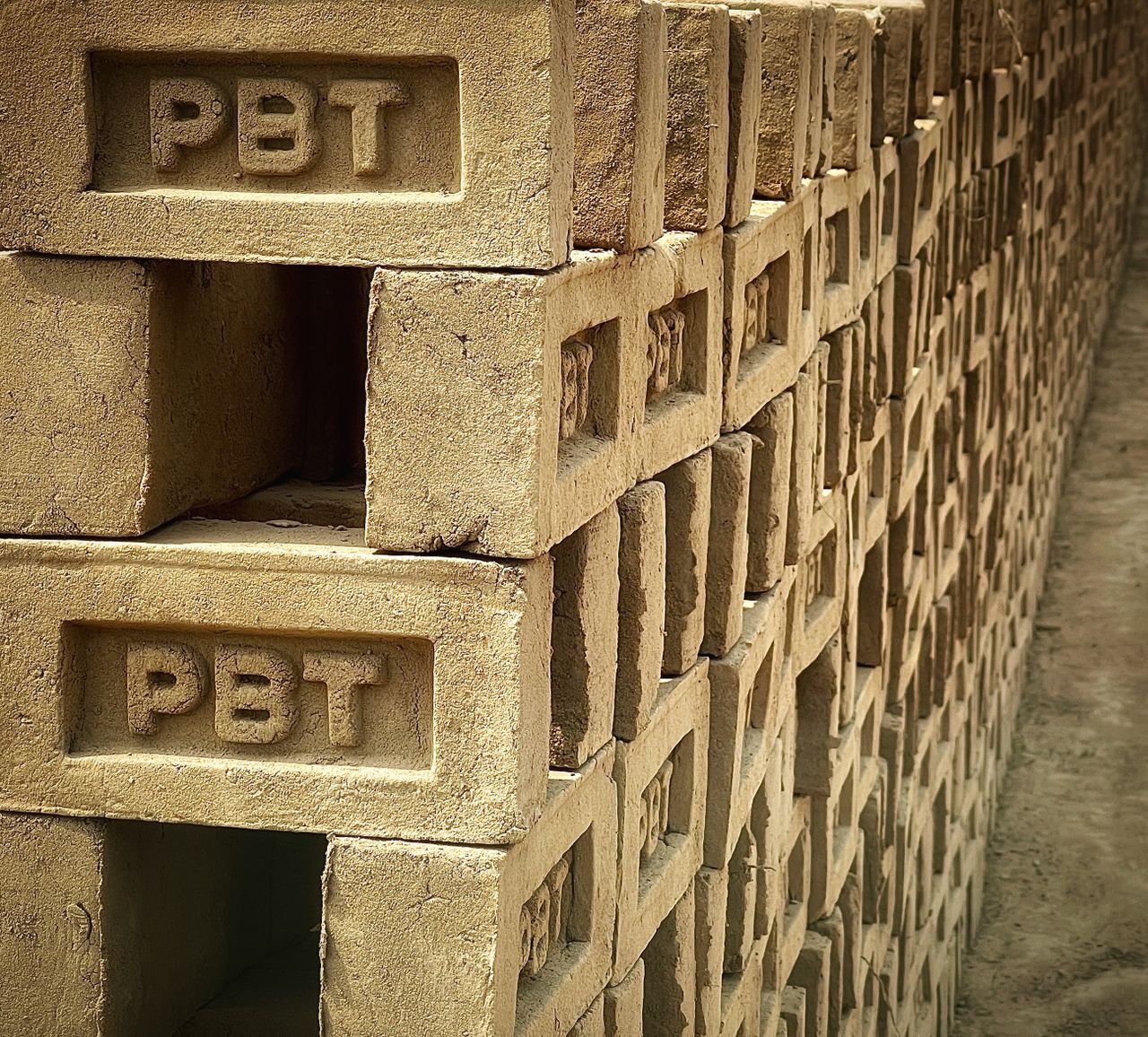 portfolio-05 Close-up of stacked concrete bricks inscribed with PBT, showcasing industrial material.
