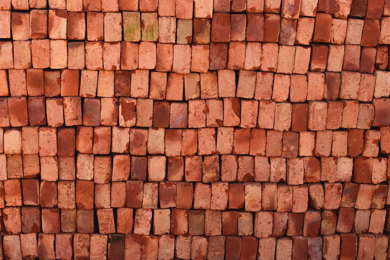 stats-img Close-up view of red bricks stacked neatly in Bangladesh, ideal for construction themes.